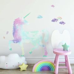 there is a unicorn wall decal next to a chair and table with a rainbow painted on it