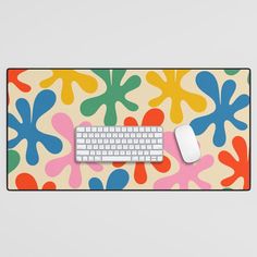 a computer keyboard and mouse sitting on top of a colorful mouse pad with an abstract design