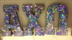 Alpha chi omega Greek letters made with cut up CDs Cute Sorority Letters Painted, Greek Letters Painted, Delta Gamma Letters Painted, Chi Omega Wooden Letters, Wood Sorority Letters, Sorority Letters Painted Wooden Big, Gingerbread Cookies Decorated, Alpha Phi Omega