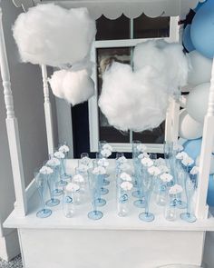 a table topped with lots of glasses and balloons