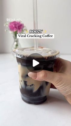 a hand holding a cup with an ice cream topping in it and the text booey virtual cracking coffee