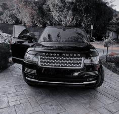 a black range rover parked in front of a house next to another car with the name range rover on it