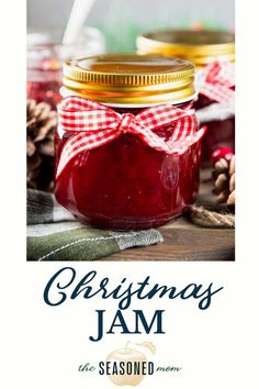 a jar filled with jam sitting on top of a wooden table next to pine cones