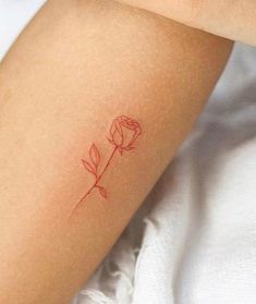 a small rose tattoo on the left arm is shown in red ink, and it appears to be tiny