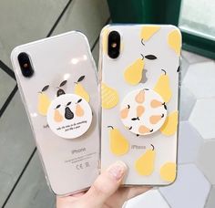 two cell phones with stickers on them, one is yellow and the other is white