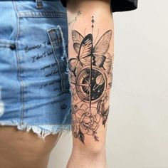 a woman's arm with a clock, flowers and butterflies tattoo on her left forearm