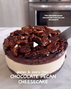 a chocolate pecan cheesecake on a counter with a knife stuck in the top