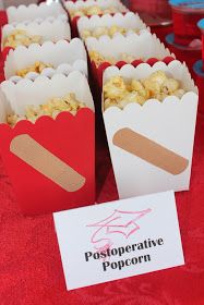 popcorn in red paper bags sitting on a table next to a sign that says poofoperative popcorn