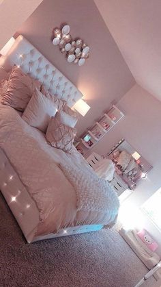 a large bed sitting in a bedroom next to a wall with lights on top of it