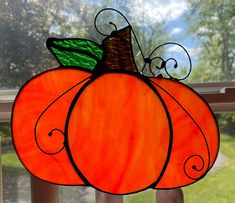 a stained glass pumpkin sitting on top of a window sill