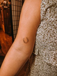 a woman with a small crescent tattoo on her arm