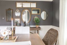 a dining room table with chairs and pictures on the wall above it, along with other decor items