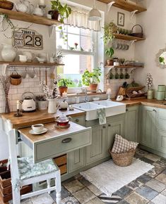 a kitchen filled with lots of green cupboards and counter top next to a window