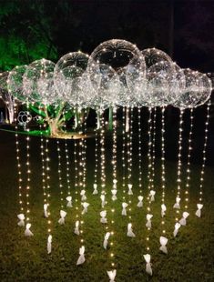 a group of white birds standing on top of a lush green field covered in lights