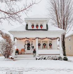 a white house with christmas decorations on the front porch