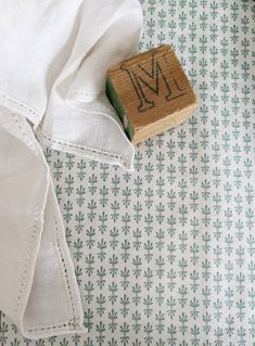 a rubber stamp with the letter m on it sitting next to a white shirt and tie