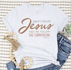 "First I Teach Jesus Then We Follow The Curriculum Shirt for Christian Teachers.  Our premium tee is soft and lightweight, with just the right amount of stretch. It's comfortable and flattering!  QUALITY We use a high quality direct to garment printing process which leaves a permanent image using high quality inks. These images will not rub, peel, or scratch off.  SIZING This shirt is unisex sized, so it may run big for women. When in doubt of your size, measure one of your shirts that you like High School Tshirt Ideas, Christian Teacher Shirts, Fall Christian Shirts, Cool Shirt Designs Graphic Tees, Teacher Shirts Designs, Popular Graphic Tees, Homeschool Shirts, Christian Shirts Designs, Scratch Off