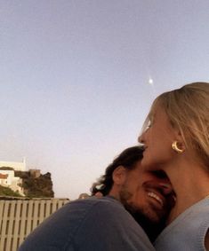 a man and woman smile at each other while standing in front of the hollywood sign