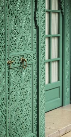 the door is green and has ornate designs on it