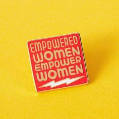 a red and white enamel pin with the words emp powered women emptished on it