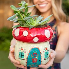 a woman holding a potted plant in her hands