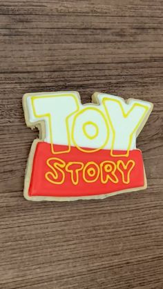 a cookie with the word toy story written on it in yellow and red icing