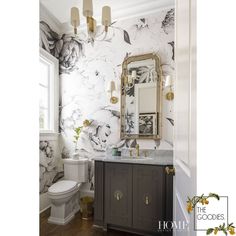 the bathroom is decorated in black and white with flowers on the wall behind the sink