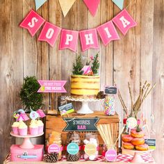 a table topped with cakes and desserts covered in pink letters that spell out the word sophiia