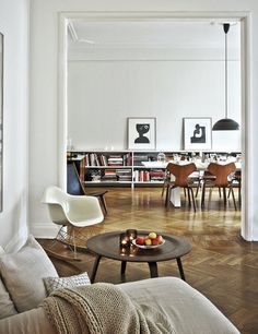 a living room filled with furniture and bookshelves next to a dining room table