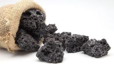 a bag full of black lava rocks sitting on top of a white table