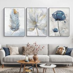 three paintings on the wall above a couch in a living room with a coffee table