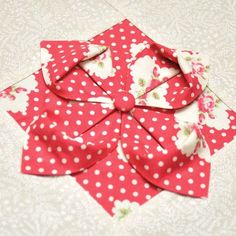 an origami flower made out of red and white polka dots on a table