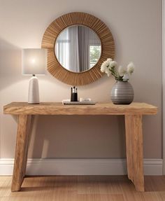 a wooden table with a mirror and vase on it