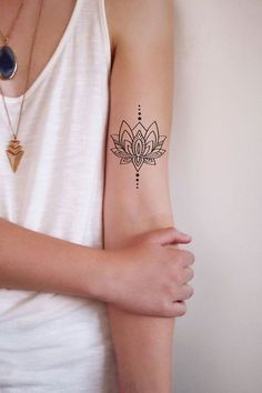 a woman's arm with a tattoo on it that has a lotus flower in the center