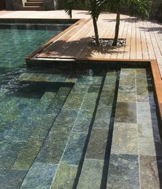 a wooden deck next to a swimming pool