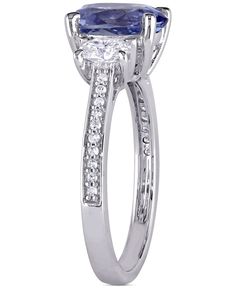 The vivid beauty of an oval-cut tanzanite is enhanced by round diamond shoulders in this elegant white gold ring. Classic Macy's Diamond Ring With Accent Stones, Macy's Classic Diamond Ring With Accent Stones, Elegant Macy's Rings For Anniversary, Classic Diamond Ring With Prong Setting By Macy's, Macy's Diamond Ring With Accent Stones For Formal Occasions, Macy's White Gold Jewelry With Accent Stones, Macy's Elegant Round Cut Diamond Ring, Macy's Fine Jewelry Rings With Accent Stones, Macy's Prong Set Cubic Zirconia Rings