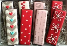 four decorated cookies in a box with hearts and bows on them for valentine's day