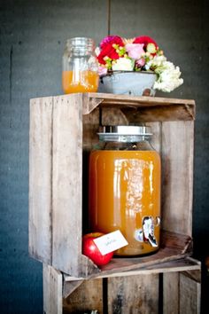 a wooden crate with jars and flowers on it