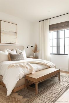 a large bed sitting in a bedroom next to a wooden dresser and window with curtains