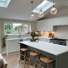 a kitchen with an island and three stools in front of the stove top oven