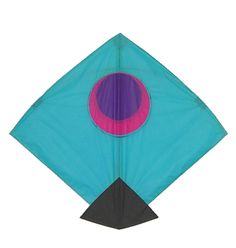 a blue kite with a pink circle on the front and black bottom, flying in the air