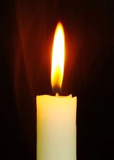 a lit candle is shown in the dark