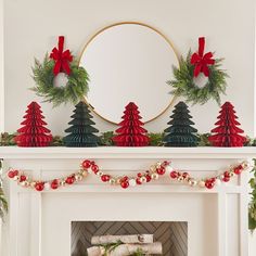 a mantel decorated with christmas decorations and wreaths