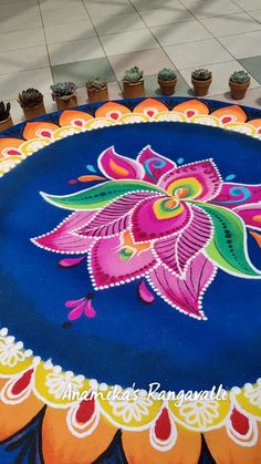 an artisticly decorated table top with potted plants on the ground in front of it