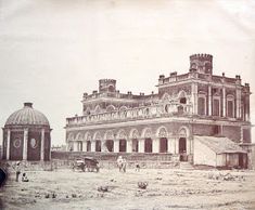 an old photo of a large building in the middle of nowhere