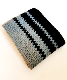 a black and blue crocheted dishcloth on a white surface