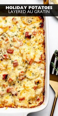 a casserole dish with meat and cheese in it on a white table next to utensils