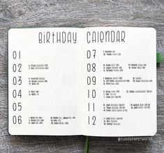 an open birthday calendar on top of a wooden table with a green flower in the middle