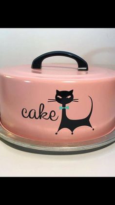 a pink cake with a black cat on the front and words that say cake written in large letters