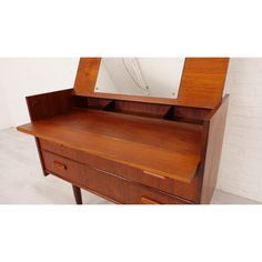 a wooden dresser with a mirror on it's top and drawers below the drawer